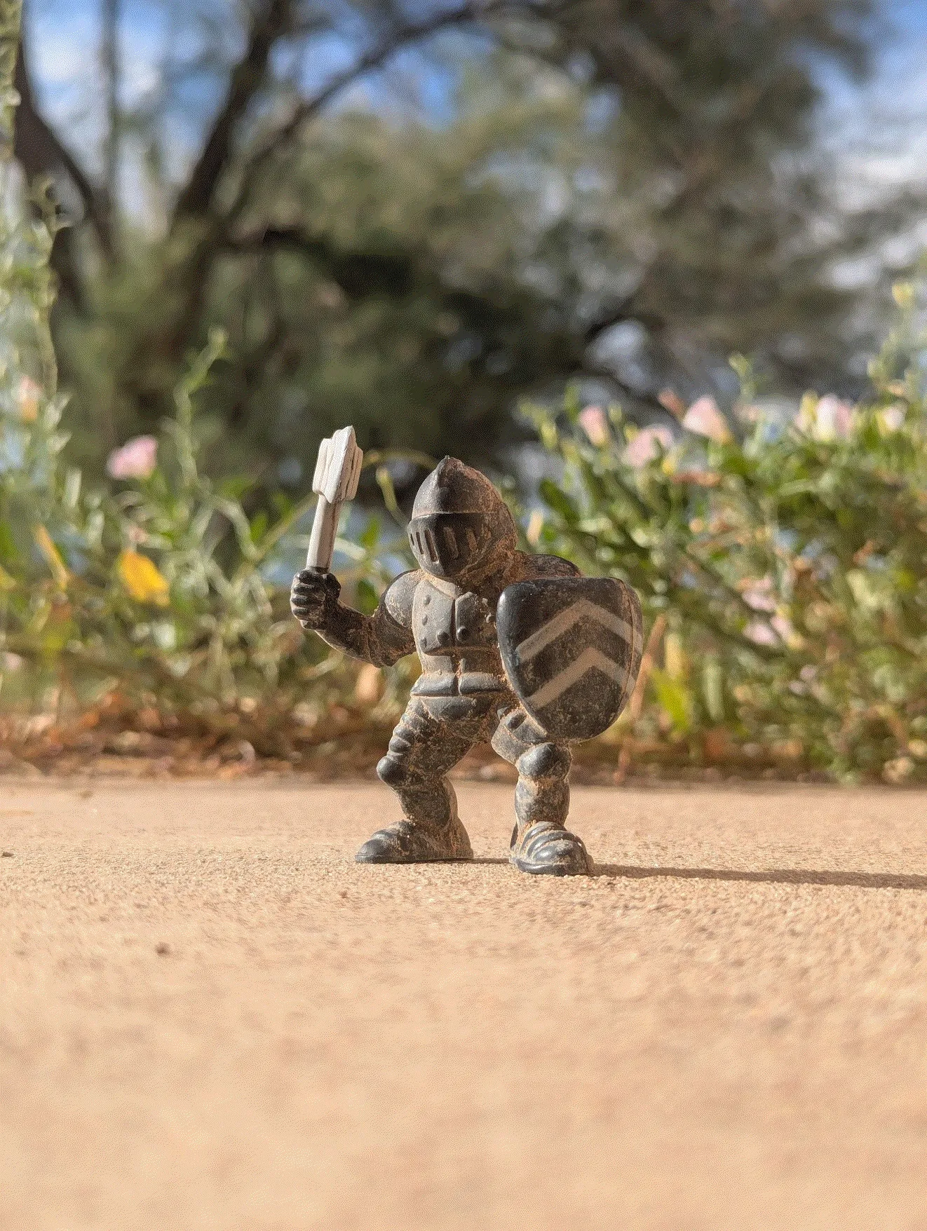 photo of figuring with an axe on concrete in front of blurry plants